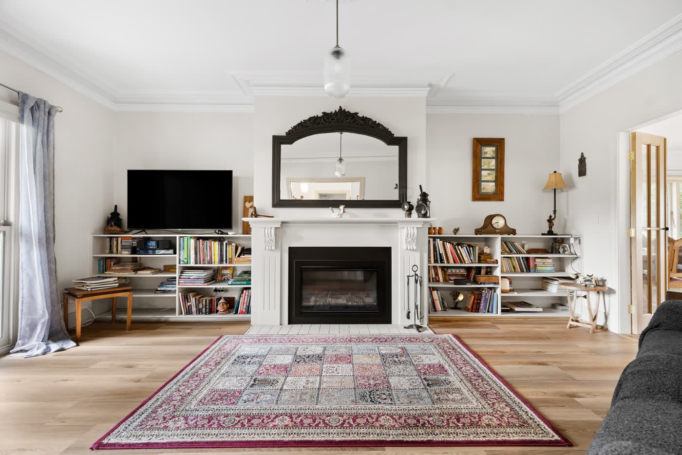 Living room with an open fire, bookshelves and a patterned rug