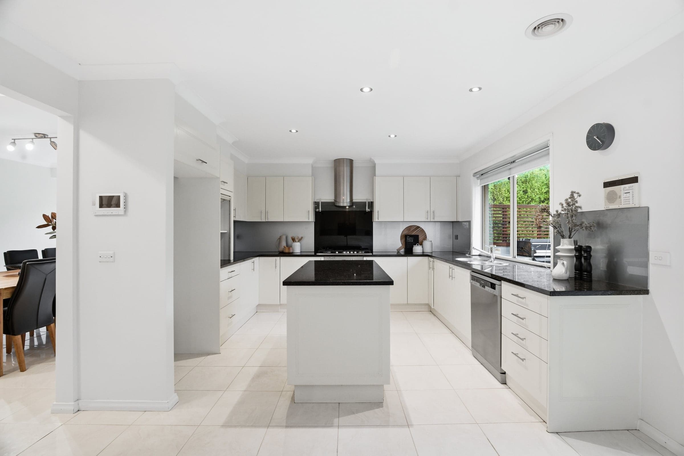 Kitchen with a stone island bench and a dark splashback