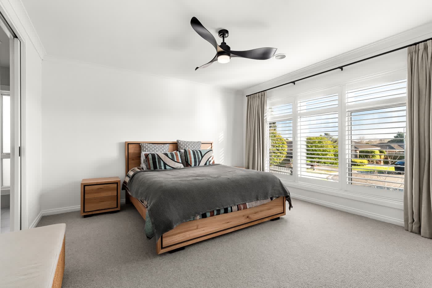 Bedroom with plantation shutters and a garden outlook