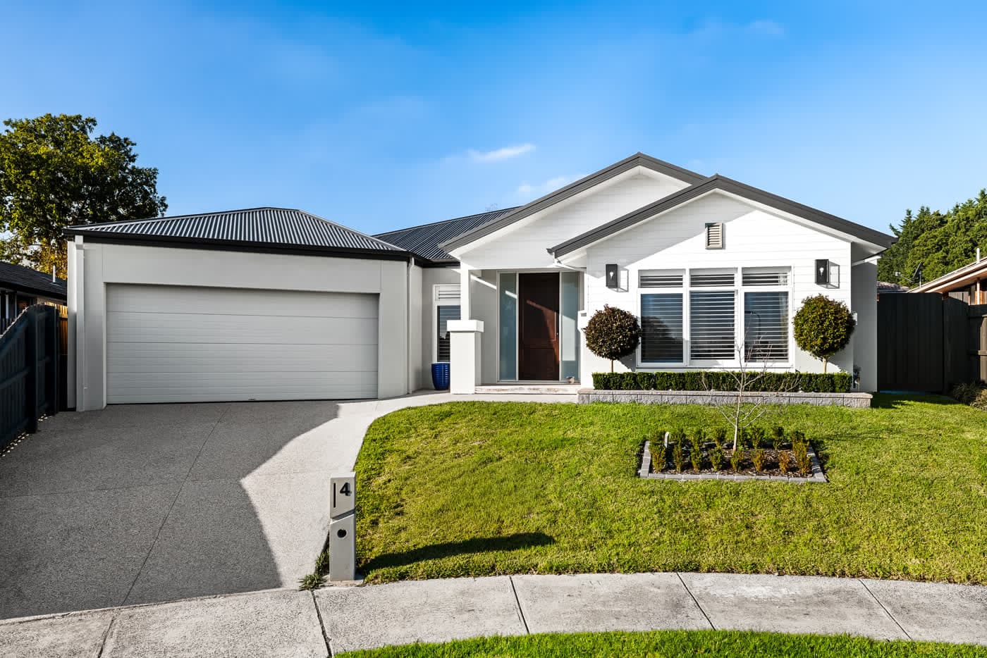 Single-storey family home behind a clipped front garden