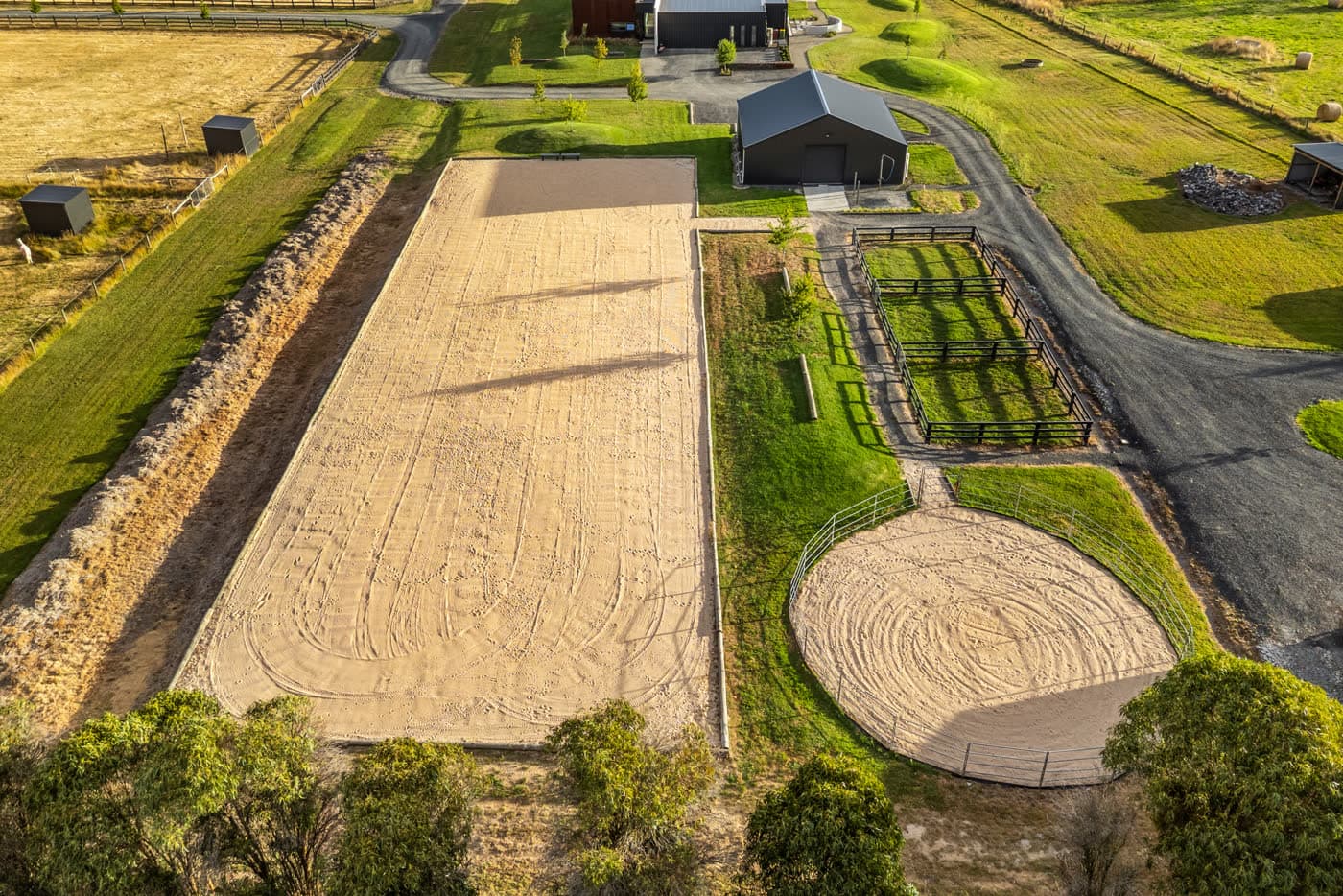 Aerial of the dressage arena, round yard and paddocks